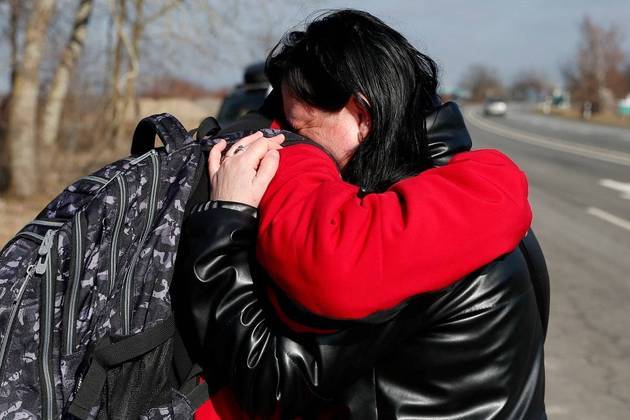 Mulher abraça a filha ao atravessar a fronteira da Hungria com a Ucrânia