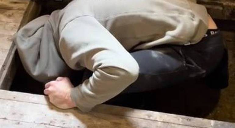 Marido de influenciadora tenta encontrar algo atrás da porta escondida em casa
