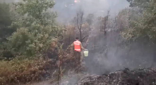 Bombeiro voluntário trabalhando em foco de incêndio em Oleiros, Portugal