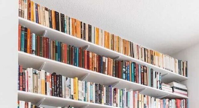 Prateleira de livros acima do rack da sala de estar