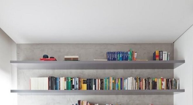 Prateleira de livros alinhada junto a parede