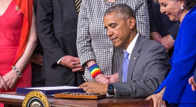 Presidente Barack Obama assinando um projeto de lei com a mão esquerda