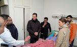 Bashar al-Assad (ao centro, com jaqueta de zíper), presidente sírio, visita um sobrevivente do terremoto no Tishreen University Hospital, na cidade de Latakia. A primeira-dama, Asma al-Assad (à direita), também estava presente