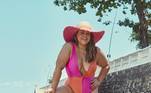 Sempre estilosa, Preta Gil posou cheia de charme com este maiô decotado de sua própria coleção. Destaque para as cores laranja e rosa, que são queridinhas em todo verãoVeja também: Cintura alta e amarrações: famosas vestem tendências de moda praia