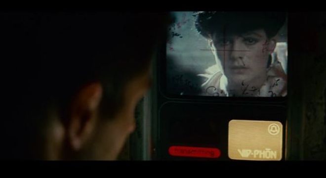 Deckard fala com Rachael por meio de uma chamada de vídeo feita em uma cabine 