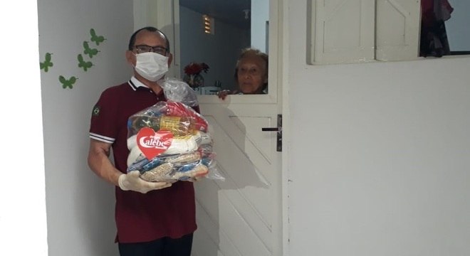 Voluntário do Calebe entrega cesta básica para idosa em isolamento