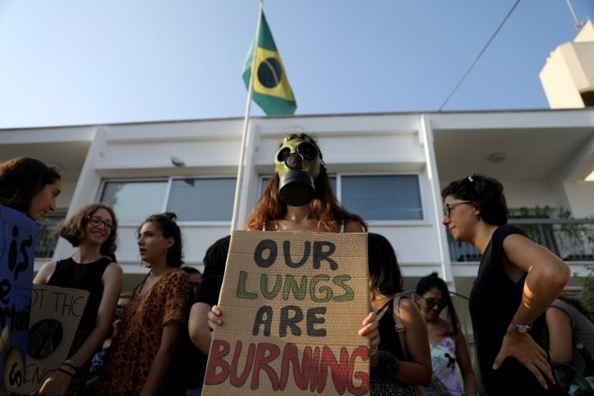 Ativistas ocuparam a rua na frente da embaixada do Brasil em NicÃ³sia, capital do Chipre. Usando uma mÃ¡scara de gÃ¡s, a manifestante segura um cartaz dizendo 'nossos pulmÃµes estÃ£o queimando