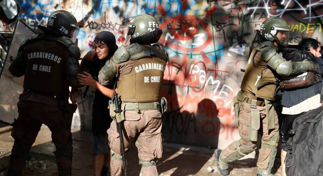 Policiais prendem dois jovens manifestantes no Chile