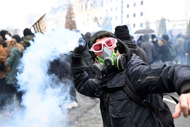 Um manifestante joga uma granada de gás contra a polícia, também em Rennes. Os protestos já acontecem na França há vários dias seguidos, uma vez que boa parte da população não aceita as mudanças na previdência que foram aprovadas pelo presidente Macron