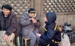 Imagem divulgada pelo Serviço de Emergência do Estado da Ucrânia mostra uma psicóloga ucraniana convencendo uma idosa a deixar um prédio residencial danificado por bombardeios russos em Kiev