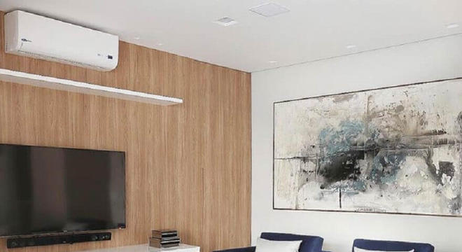 Quadros grandes para sala de estar com poltrona azul e parede revestida de madeira