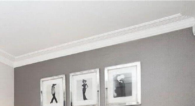 quarto cinza e branco decorado com abajur e criado mudo preto 