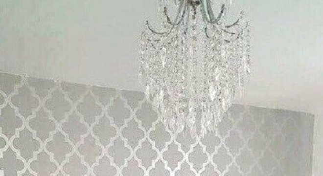 quarto de casal decorado com lustre de cristal e papel de parede cinza com acabamento metalizado
