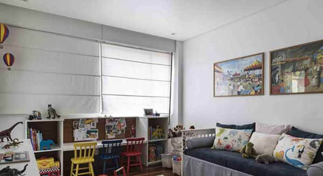 Quarto infantil planejado com cadeiras coloridas e tapete listrado