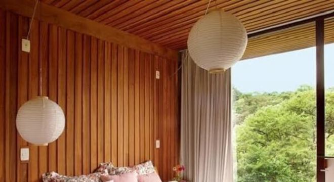 Quarto rústico de casal com revestimento de madeira