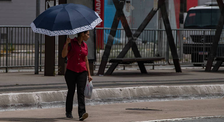 Mulher se protege contra o sol em São Paulo