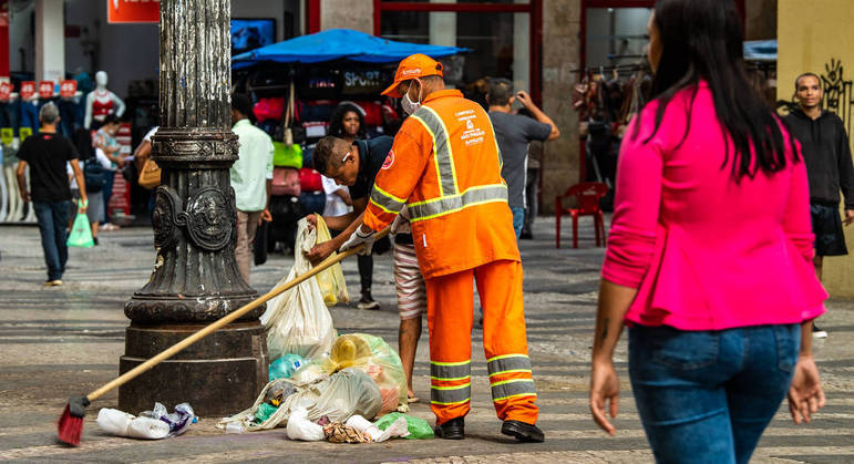 Gari limpa calçada na rua Barão de Itapetininga (SP)
