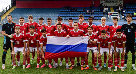 Jogadores da seleção russa carregam bandeira do país em foto pré-jogo
