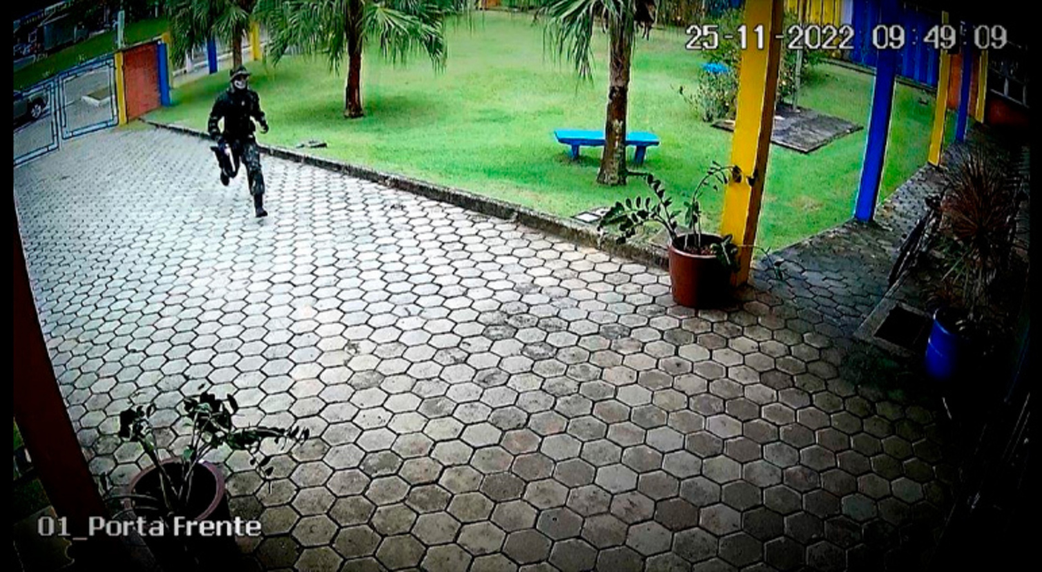 O adolescente chega ao colégio particular armado e com o rosto tampado  (Reprodução/Record TV)