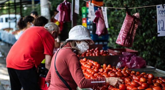 Consumidores compram tomates em feira livre da cidade de São Paulo