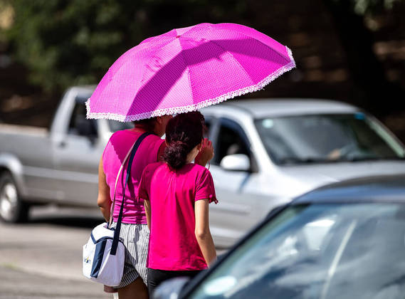 são Paulo, SP - 29.03.2023  Calor intenso nesta quarta-feira na cidade. Mãe e filha se protegem ao caminhar pela av. Inajar de Souza. Foto Edu Garcia/R7