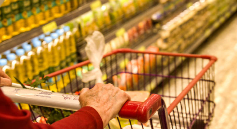 Mulher fazendo compras no supermercado; inflação subiu para alimentos e caiu para transportes em julho no DF