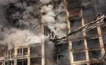 Bombeiros tentam apagar fogo em prédio atingido por ataque russo em Kiev