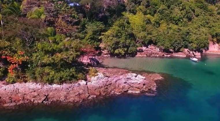 A praia privativa, com água cristalina, é um dos destaques da ilha cercada de área verde