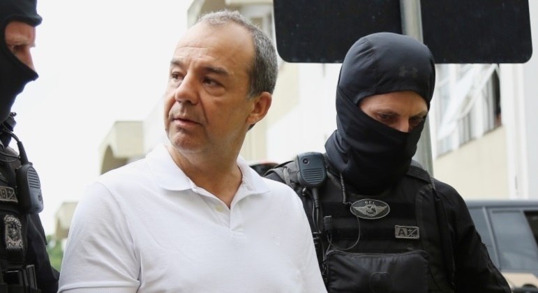 Sérgio Cabral sendo conduzido por policiais; ele já foi condenado a quase 400 anos de prisão