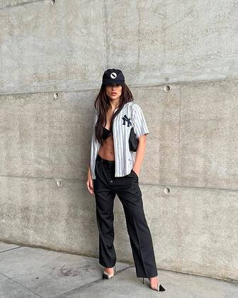Recentemente, ela surgiu com um look meio esportivo, meio formal, composto de calça e bolsa pretas, salto alto, sutiã à mostra, camisa de baseball listrada, do time New York Yankees, e boné