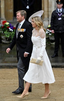 A rainha Maxima, da dos Países Baixos, elegeu o branco como cor para o look monocromático. Ela usou um vestido midi de mangas longas, mas com um detalhe de renda na altura do colo. O chapéu da monarca, com a aba voltada para cima, também foi um ponto de destaque