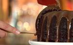 Bolo de Chocolate com Café Ingredientes da Massa:  
90g de manteiga 

80g de açúcar refinado 

80g de açúcar mascavo 

120g de ovos (2 unidades) 

140ml de iogurte natural 

140g de farinha de trigo 

40g de cacau em pó 50%  

25ml de óleo 

10g de café solúvel em pó 

10g de essência de baunilha 

10 de bicarbonato de sódio 

15g fermento em pó químico 
Pitada de sal 

 

Modo de Preparo:  

Na batedeira, coloque a manteiga
e o açúcar. Quando estiver um creme, adicione os ovos;    Misture o restante dos
ingredientes; 

Coloque numa assadeira untada com
manteiga e farinha de trigo;Asse a 180°C por 25 minutos. 

 

Cobertura: Ganache de café 

Ingredientes: 

70g de chocolate branco 

50g de chocolate ao leite 

70g de creme de leite  

10g de café solúvel 

10g de canela em pó 

 

Modo de Preparo: 

Aqueça o creme de leite com o
café e a canela;   Derrame o creme de leite sobre os
chocolates. Mexa até derreter;Cubra o bolo.Tempo de preparo: 50
minutos
