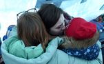 Família se abraça numa tenda montada perto de uma estação de trem na cidade de Lviv, na Ucrânia