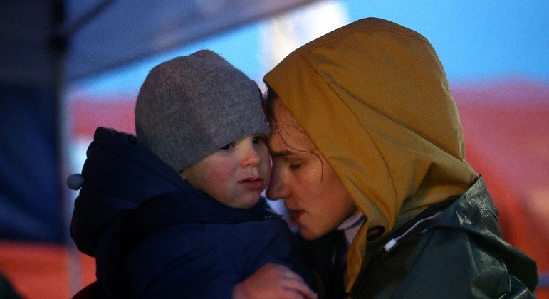 Refugiados ucranianos enquanto esperam para embarcar em um ônibus na Polônia