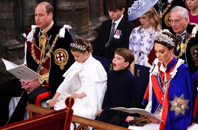 Príncipe Louis boceja durante a cerimônia de coroação de seu avô. Ele está ao lado de sua irmã e de seus pais, William e Kate Middleton