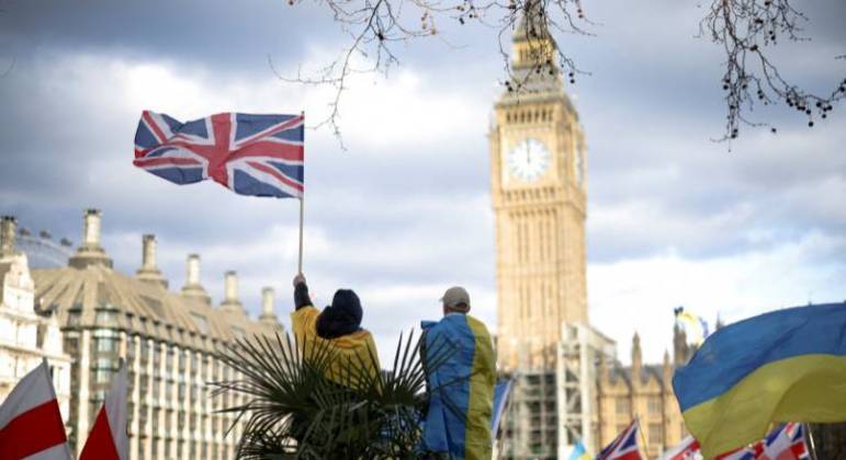 Manifestante segura bandeira britânica durante protesto contra a invasão russa da Ucrânia
