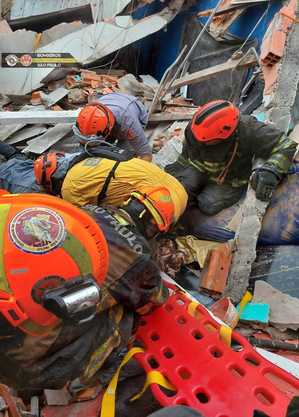 Bombeiros resgatam vítimas dos escombros da residência
