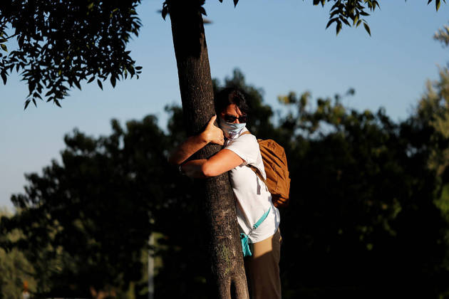 A woman takes part in a campaign by Israel's Nature and Parks Authority calling on people to join sightseeing tours and find comfort in tree hugging amid a spike in the coronavirus disease (COVID-19), in Jerusalem July 9, 2020. Picture taken July 9, 2020. REUTERS/Ronen Zvulun