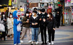 People walk past a worker in Japanese animation character Doraemon costume amid the coronavirus disease (COVID-19) pandemic at a shopping district in Seoul, South Korea, November 24, 2020. REUTERS/Kim Hong-Ji