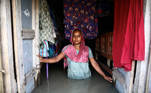 A woman stands in the water as she poses for a picture in her flooded house in Bogura, Bangladesh July 17, 2020. REUTERS/Mohammad Ponir Hossain