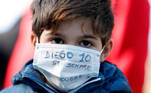 Soccer Football - People mourn the death of Argentine soccer legend Diego Maradona, Naples, Italy - November 26, 2020 A boy wearing a protective face mask is seen outside the Stadio San Paolo REUTERS/Yara Nardi