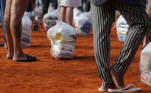 People stand to receive food aid distributed by the "G10 das Favelas", a group of slum's entrepreneurs, amid the coronavirus disease (COVID-19) pandemic at Heliopolis slum in Sao Paulo, Brazil April 14, 2021. REUTERS/Carla Carniel