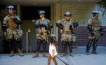 A child carrying a small broom walks by a line of National Guard members deployed to Bellevue Square as community members clean up after looting and vandalism that occurred Sunday at Bellevue Square in downtown Bellevue, Washington, U.S. June 1, 2020. REUTERS/Lindsey Wasson TPX IMAGES OF THE DAY