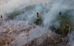 A bird flies as smoke from burning vegetation rises in Brazilian Amazon rainforest, in Apui, Amazonas state, Brazil, September 4, 2021. Picture taken with a drone September 4, 2021. REUTERS/Bruno Kelly