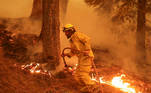 A firefighter continues to hold the line of the Dixie Fire near Taylorsville, California, U.S., August 10, 2021. REUTERS/David Swanson