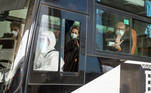 Members of the World Health Organisation (WHO) team tasked with investigating the origins of the coronavirus disease (COVID-19) pandemic sit on a bus while leaving Wuhan Tianhe International Airport in Wuhan, Hubei province, China January 14, 2021. REUTERS/Thomas Peter TPX IMAGES OF THE DAY