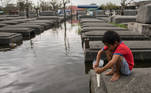 A boy attempts to keep a candle lit in a flooded cemetery following Typhoon Molave, in Masantol, Pampanga, Philippines, October 27, 2020. REUTERS/Eloisa Lopez