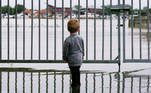A child looks on as water floods through a fence, in Wessem, Netherlands, July 16, 2021. REUTERS/Eva Plevier