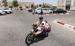 Um israelense pilota a moto com as duas filhas depois de receber flores de compatriotas em shopping center de Ashkelon. O primeiro-ministro israelense, Benjamin Netanyahu, classificou como um 'êxito excepcional' a ofensiva do exército contra o Hamas