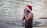 A swimmer wearing a Santa hat gets out of The Serpentine lake at Hyde Park on Christmas Day, as the spread of the coronavirus disease (COVID-19) continues, in London, Britain, December 25, 2020. REUTERS/Hannah McKay
